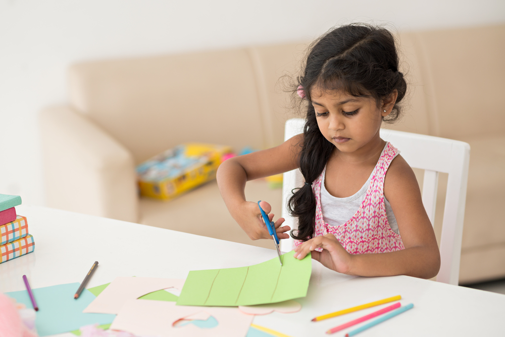 girl cutting with scissors art project